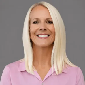Smiling woman in a pink blouse.