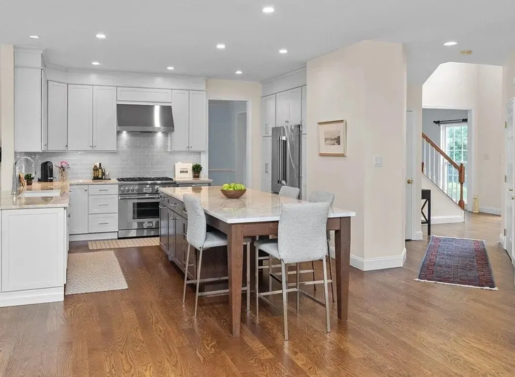 Modern kitchen with island and wooden floor.