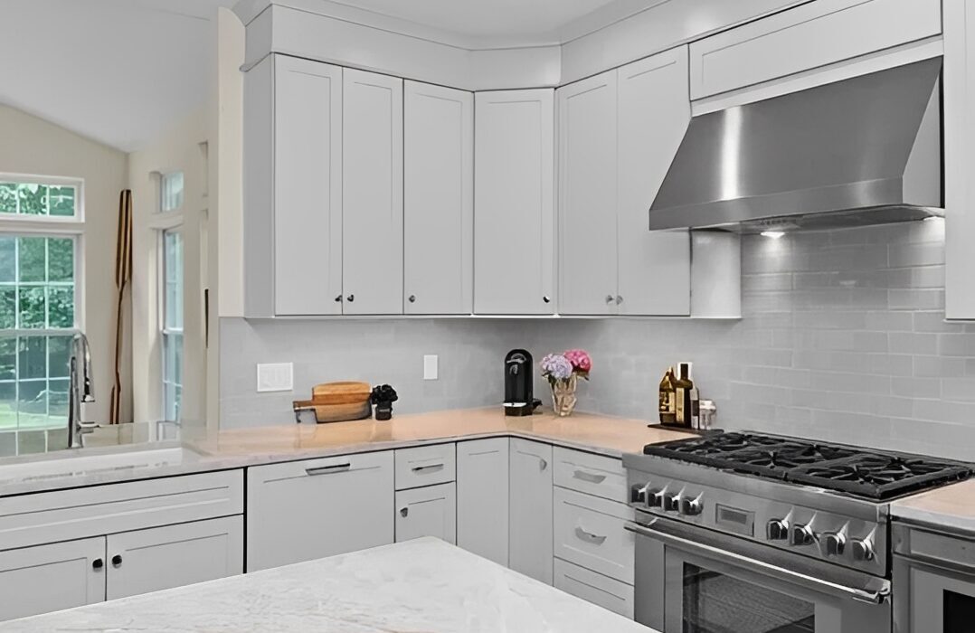 Modern kitchen with white cabinets and stove.