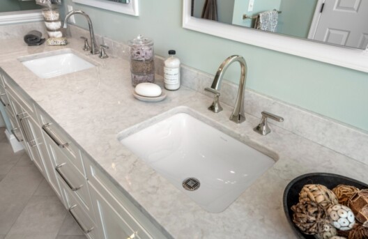 Bathroom countertop with double sinks and decor.