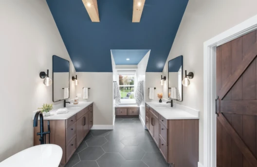 Modern bathroom with dual vanities and blue ceiling accents.