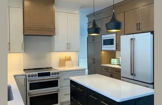 Modern kitchen with island and pendant lights.