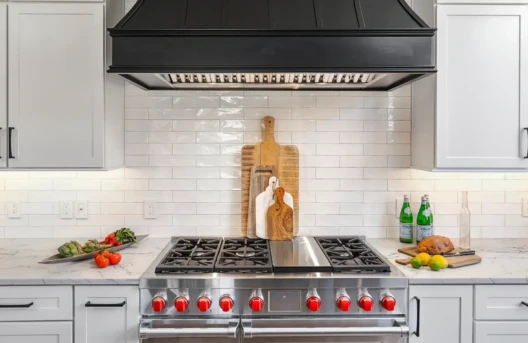 Modern kitchen with stove and black hood.
