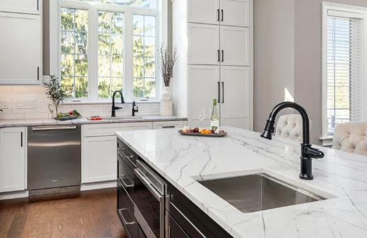 Modern kitchen with marble countertops and island.