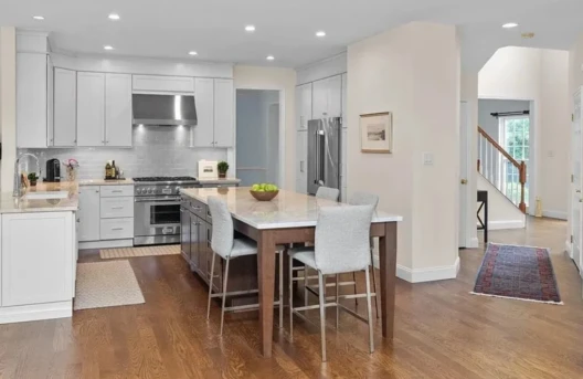 Modern kitchen with island and wooden floor.