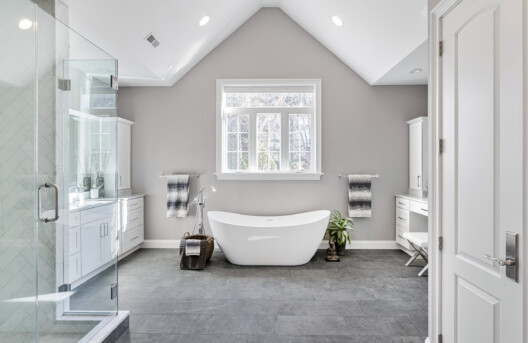 Primary Bathroom Remodel in Lower Gwynned Township, Ambler, PA. Features 4" x 12" Honed White Carrara Marble In The Shower With Full Back-Wall Shelf, Freestanding Tub, Dual Vanities with Marble Tops, Glass Shower Enclosure, and Custom White Cabinetry and Built-In Bench