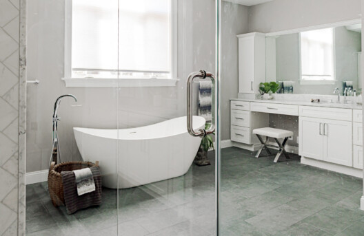 Primary Bathroom Remodel in Lower Gwynned Township, Ambler, PA. Features 4" x 12" Honed White Carrara Marble In The Shower With Full Back-Wall Shelf, Freestanding Tub, Dual Vanities with Marble Tops, Glass Shower Enclosure, and Custom White Cabinetry and Built-In Bench