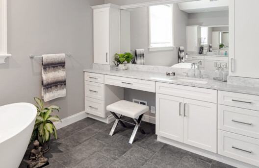 Primary Bathroom Remodel in Lower Gwynned Township, Ambler, PA. Features 4" x 12" Honed White Carrara Marble In The Shower With Full Back-Wall Shelf, Freestanding Tub, Dual Vanities with Marble Tops, Glass Shower Enclosure, and Custom White Cabinetry and Built-In Bench
